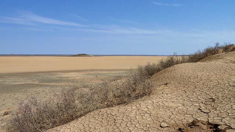 View across a now-dry lakebed near Swartkolkvloer. During the last glacial period this and adjacent basin supported what are believed to have been perennial lakes, some up to 60 feet in depth. Image credit: Brian Chase.