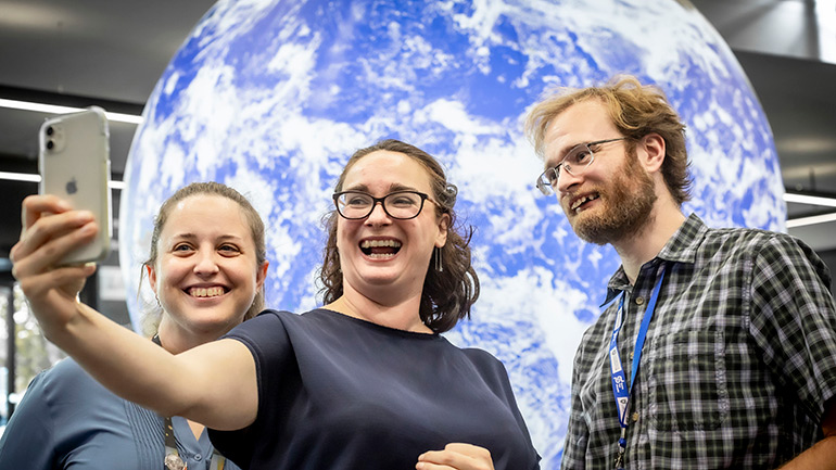 Visitors in front of the Space Park Leicester globe.