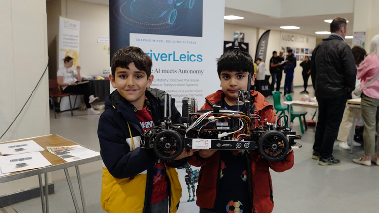 Visitors to the DriverLeics exhibit at the Bright Sparks STEM fair, including Zavi (left).