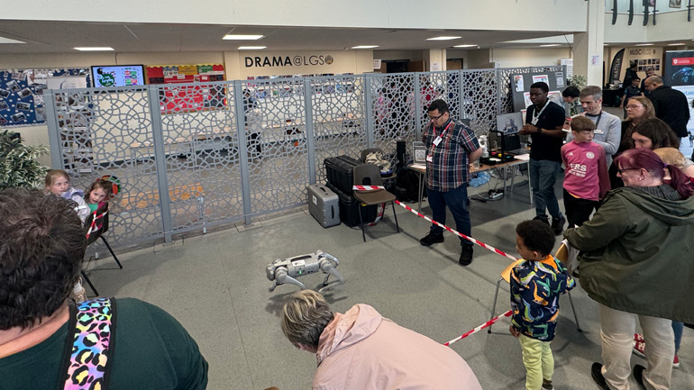 The DriverLeics team demonstrating the robotic dog to visitors.