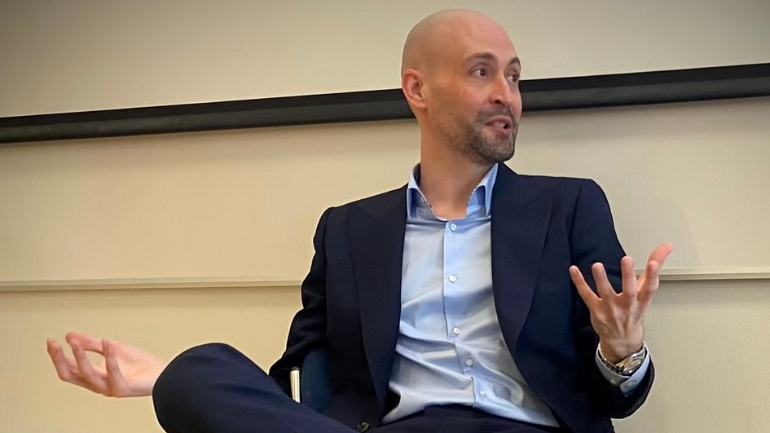 Will Darler sitting on a chair during a question and answer event
