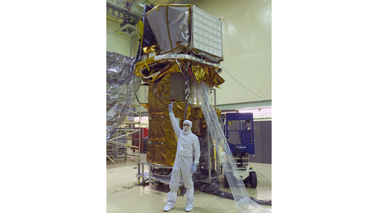The Neil Gehrels Swift Observatory in the clean room at NASA Goddard Space Flight Center; with Neil Gehrels standing in front of it. CREDIT: NASA