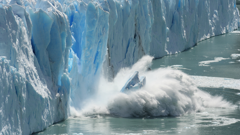 A chunk of ice dropping off a glacier into the sea