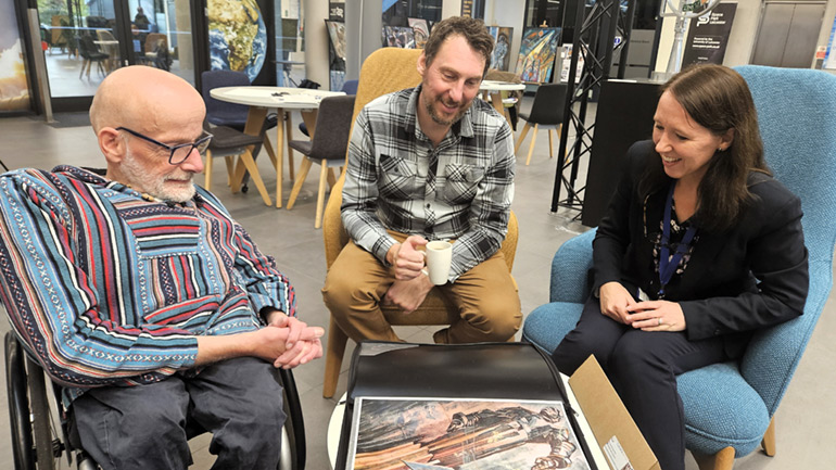 Artist Matt Turner (centre) meets visitors at an exhibition of his work at Space Park Leicester.