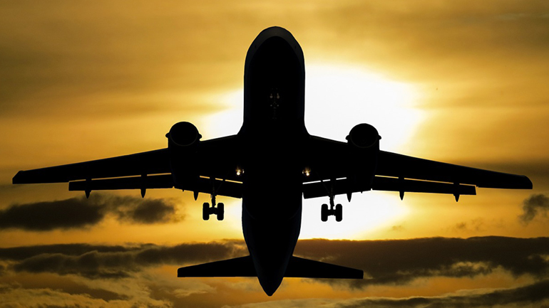 An aircraft flying at sunset.