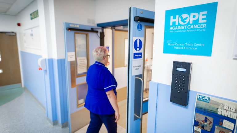 NHS staff member walking into a hospital ward
