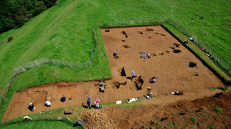 Excavation of an Iron Age roundhouse, pits, and a cross-section of the hillfort ramparts at Burrough Hill, ©ULAS 