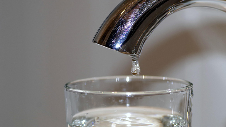 A tap dripping water into a glass.