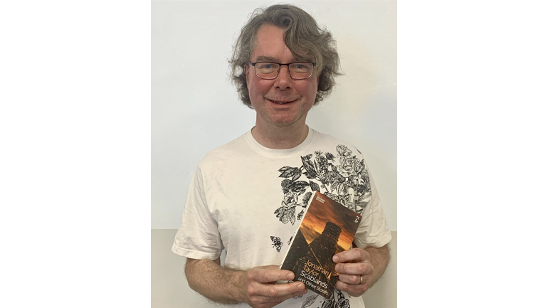 Dr Jonathan Taylor holds his book, Scablands and Other Stories
