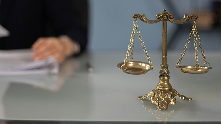 A scales on a desk, representing justice.