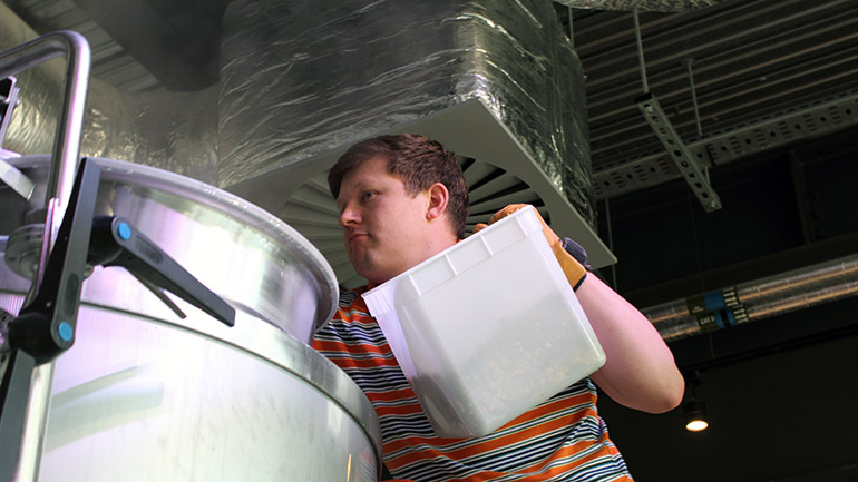 Josh Smalley adding ingredients in the brewery.