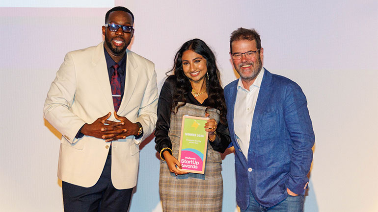 Leya (centre) pictured at the award ceremony with comedian and host Calvin Eden (left) and Professor Dylan Jones-Evans OBE (right). 