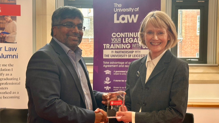 Professor Sir Nishan Canagarajah and Professor Andrea Nollent shaking hands while holding an award at a partnership event.