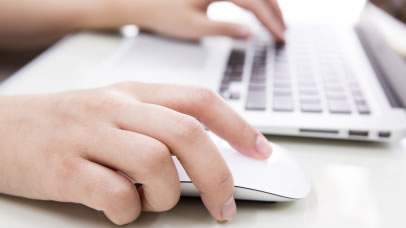 person using a mouse and laptop