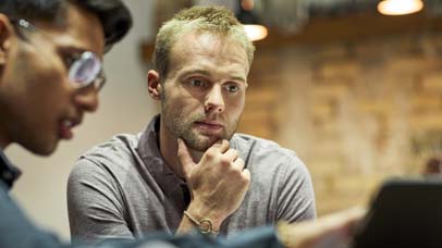 Determined male entrepreneur is looking at digital tablet
