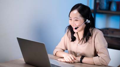 Asian female customer care service smiling and working hard late at night shift at office.
