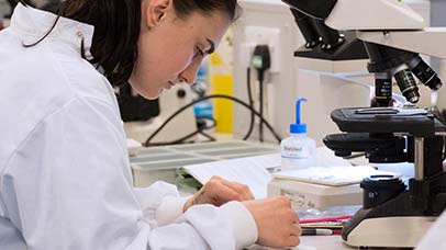 person using a microscope in a lab