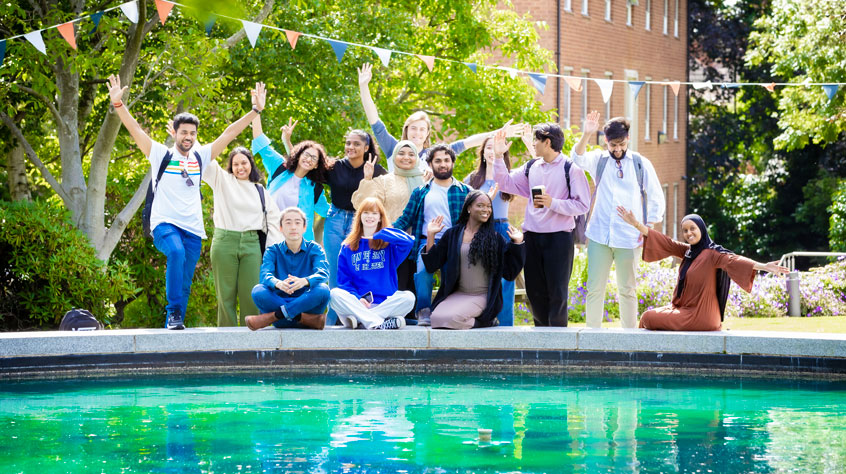 Students posing at the pond at Brookfield on University of Leicester campus