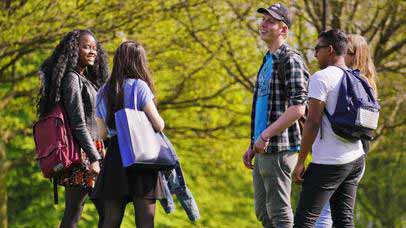 A group of students talking and laughing outside.