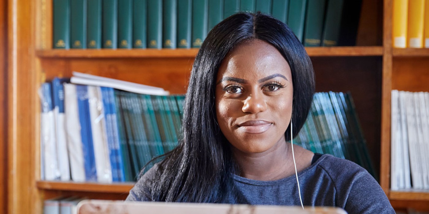 Student studying on laptop in a library