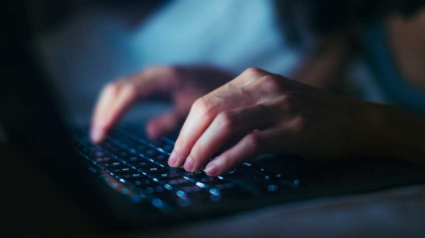 Hands typing on a keyboard