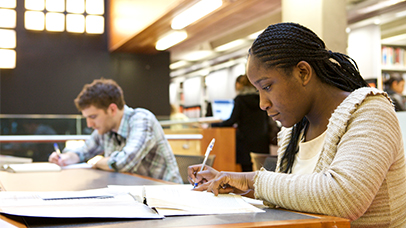 international student writing in the library