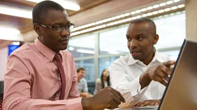 Two people sat working at a desk together