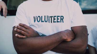 Person wearing a t-shirt which says 'volunteer'