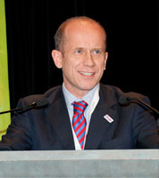 Tom Robinson standing at a lectern delivering a speech.