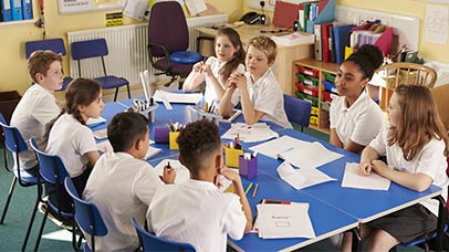 children working together on large table in classroom