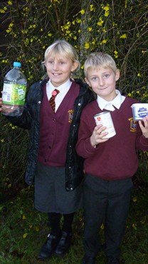 Two children holding waste items