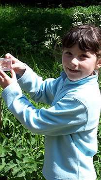 Child holding up a bug pot