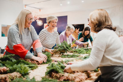 Group of women making a Christmas wreath in a floristry workshop