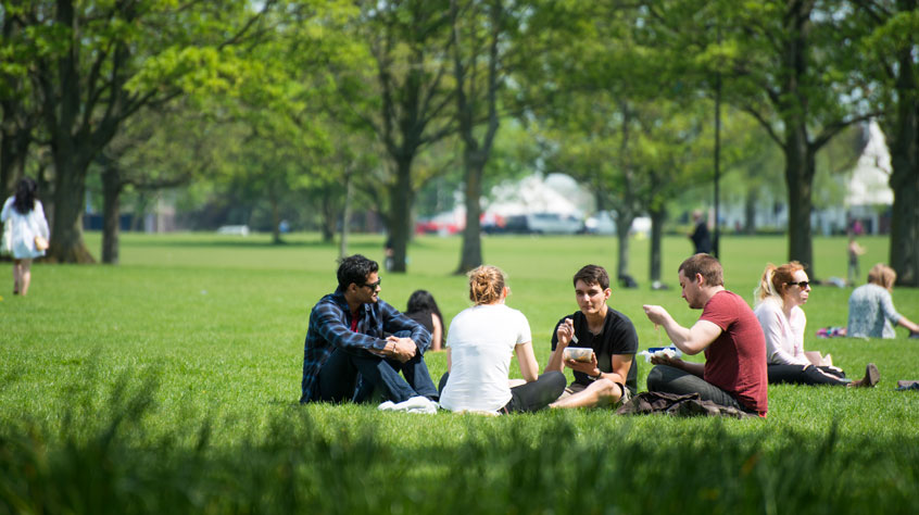Students sitting in Victoria Park, eating lunch