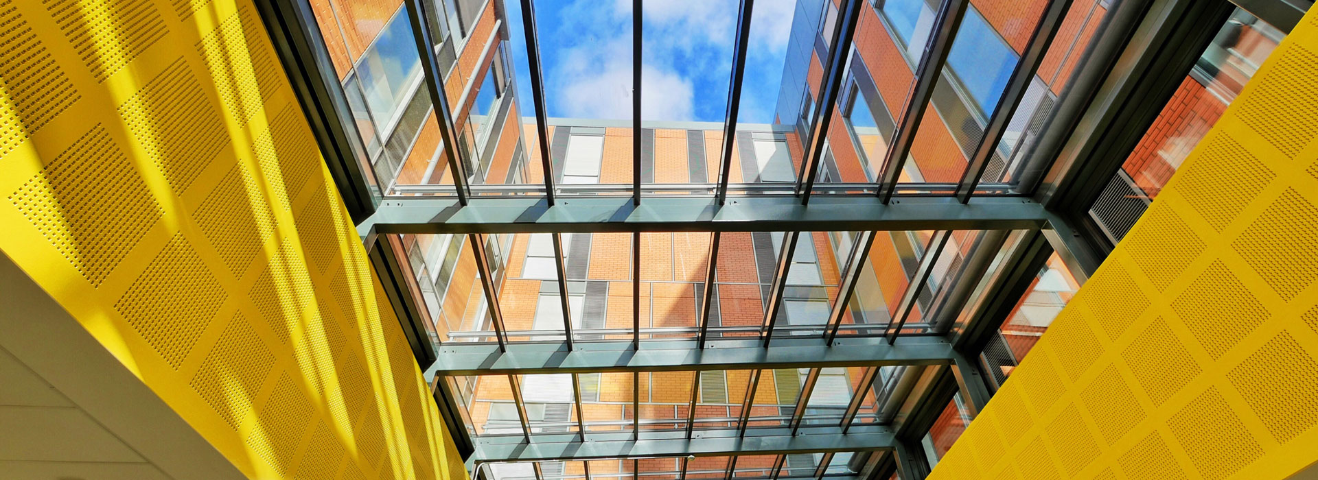 An atrium in a building with a blue sky above it.