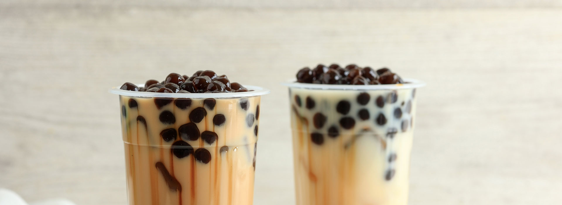 Two cups of bubble tea on a table.