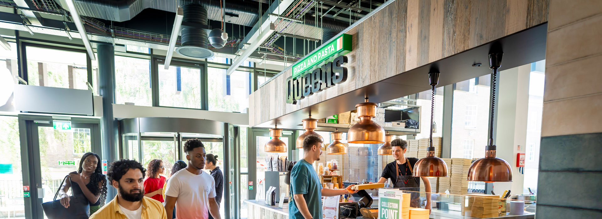 Students walking past and ordering at a campus food outlet in the Students' Union.