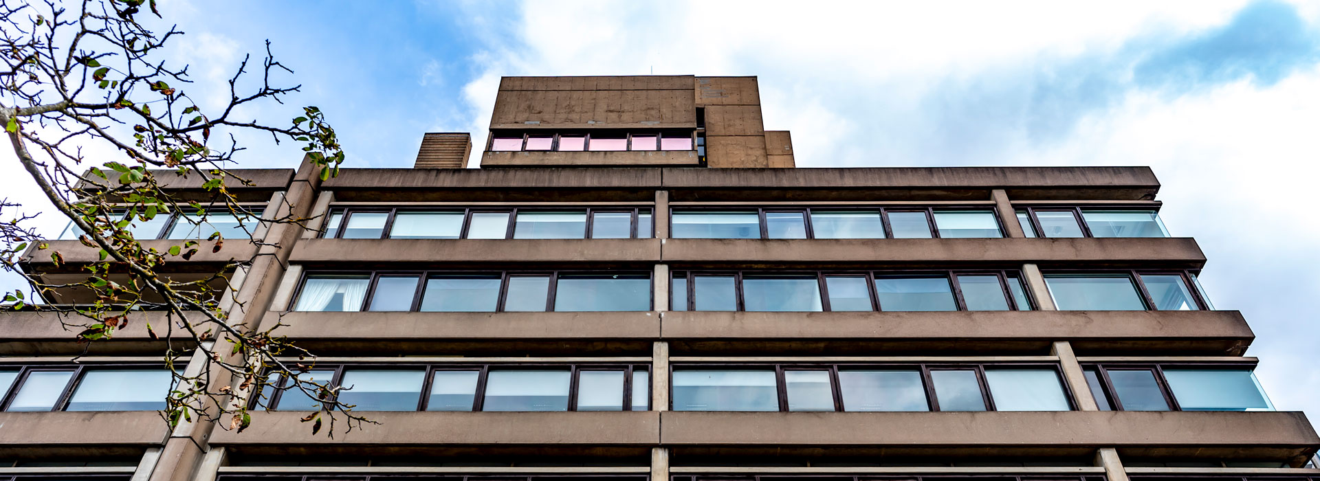 A view of the Charles Wilson Building on Leicester campus with a blue sky above it.
