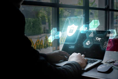 female on laptop with cyber security logo on screen
