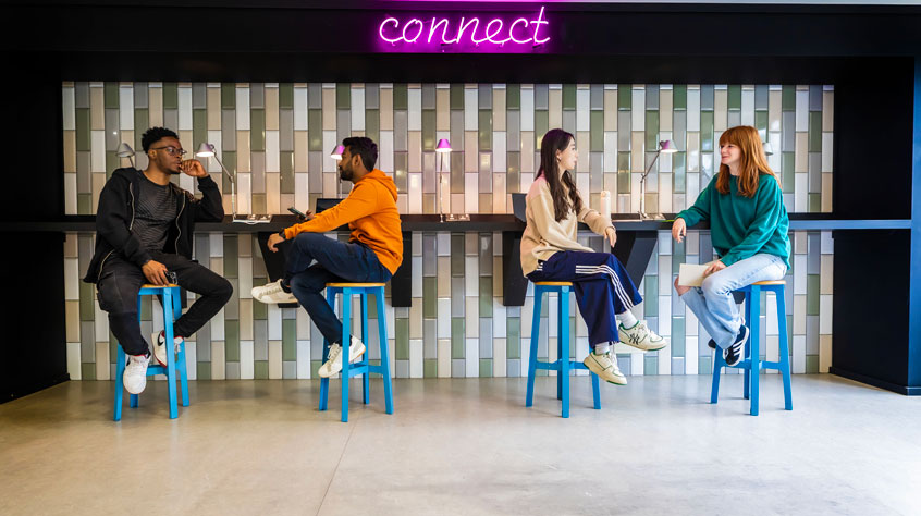 Students sitting on a long bench, with the word 'connect' above them on the wall