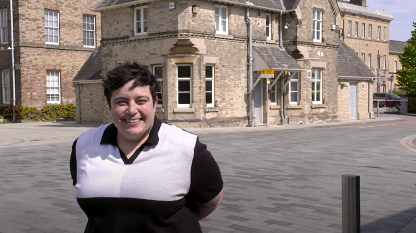 Fran Beever smiling into the camera with the Security hut in the background
