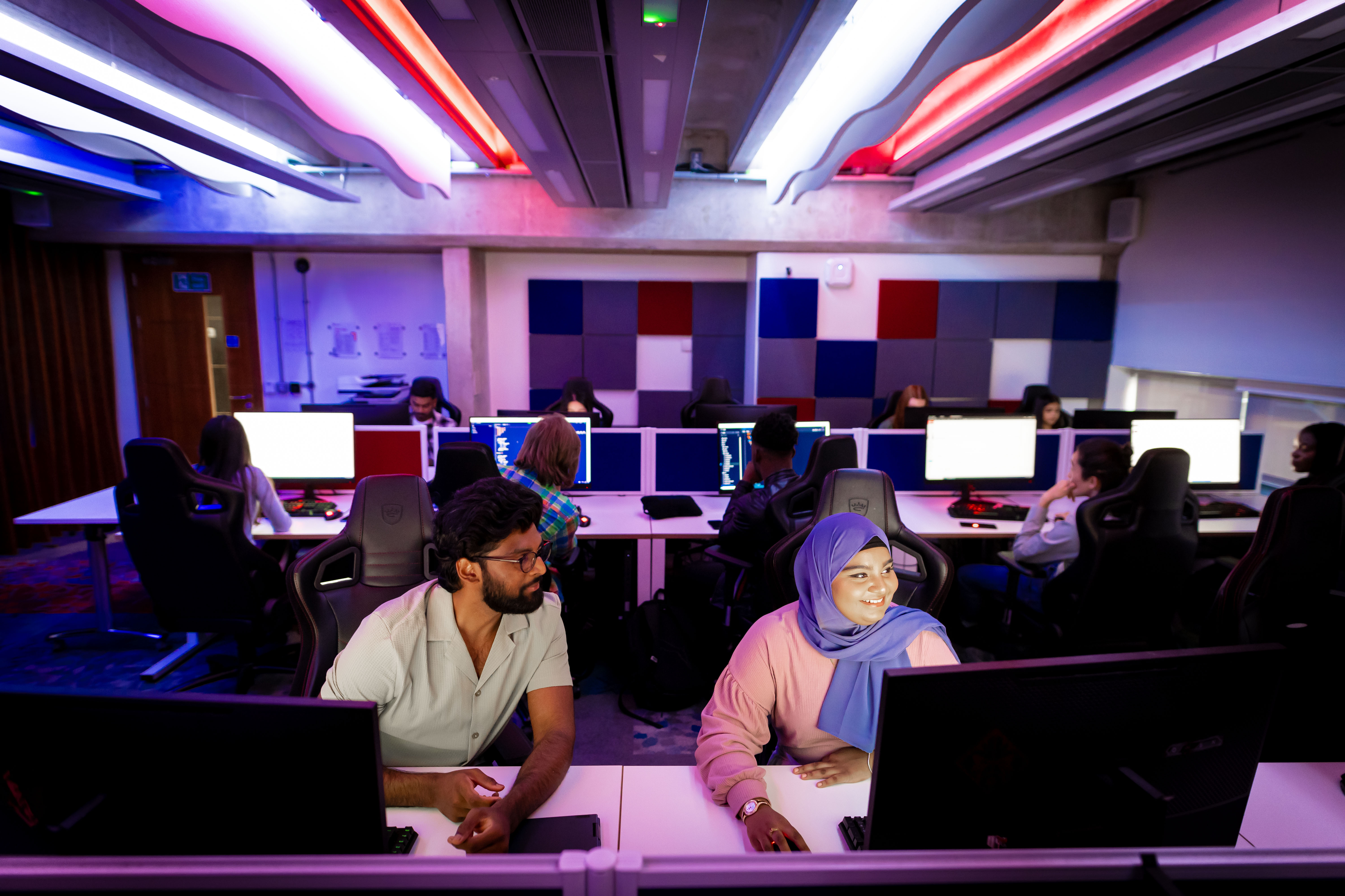 A male and female student  working in a computer lab