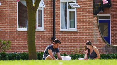 Two people studying outside building