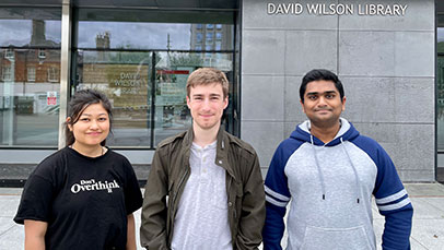 Three people standing outside David Wilson Library building