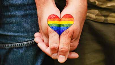 People holding hands, which creates a rainbow flag heart