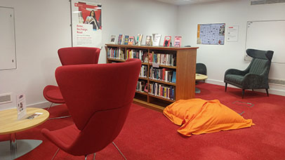 The reading lounge in the library with bookshelves and armchairs
