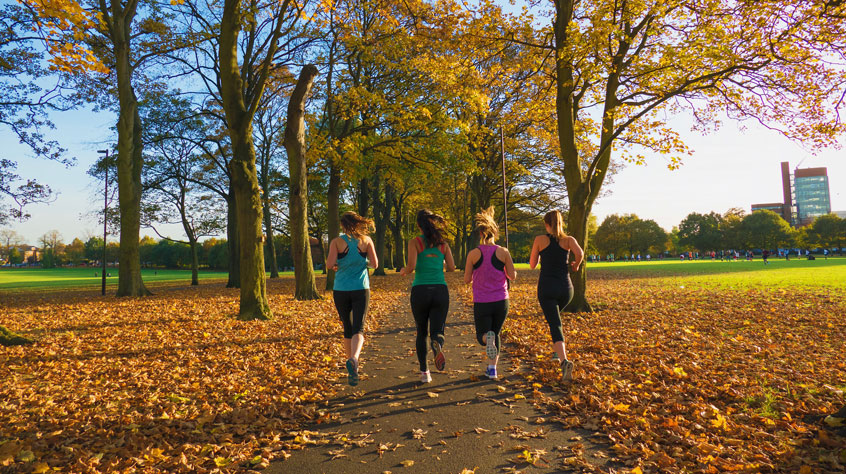 Four women running in Victoria Park in Leicester.