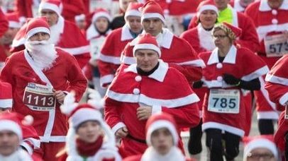A group of competitive runners each racing whilst wearing a Santa Claus costume