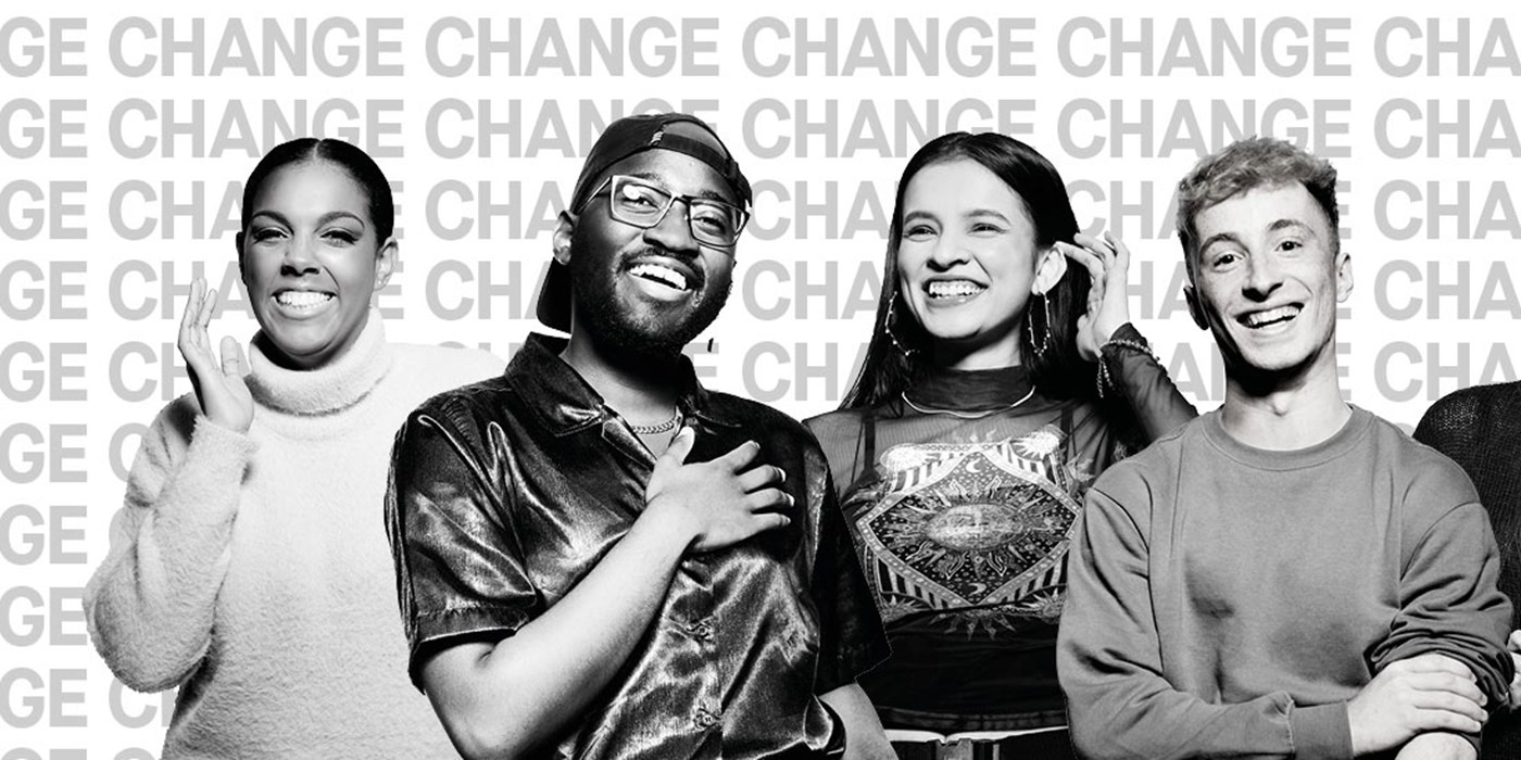 Black and white image of a diverse group of University of Leicester students standing in front of backdrop of poster of the repeated phrase change