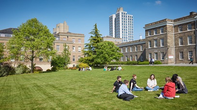 Students sitting on the grass outside the Fielding Johnson building on a sunny day